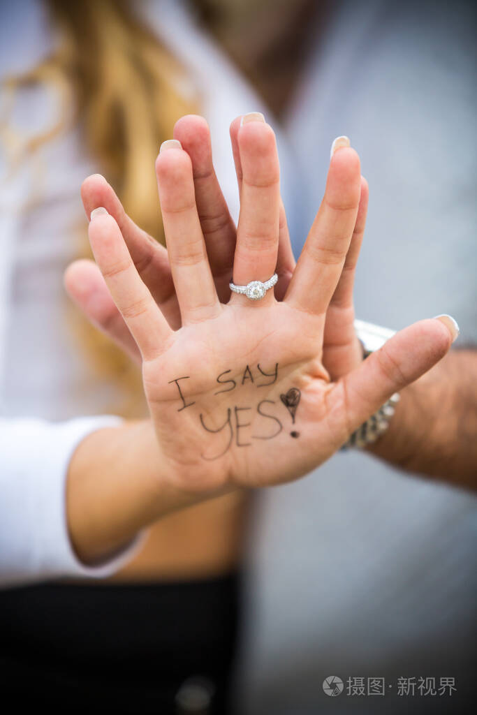 我答应了字写在女人手上婚戒在手上男人的手在后面