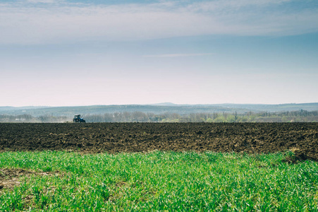 tractor plows a field 