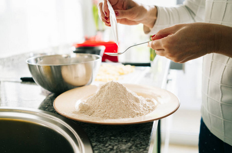 Woman prepares the ingredients to make a sponge cake 