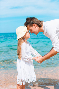 小女孩和快乐的爸爸在海滩度假玩得开心