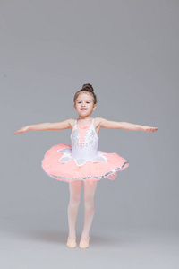 可爱可爱的芭蕾舞演员穿着粉色芭蕾舞裙练习芭蕾舞