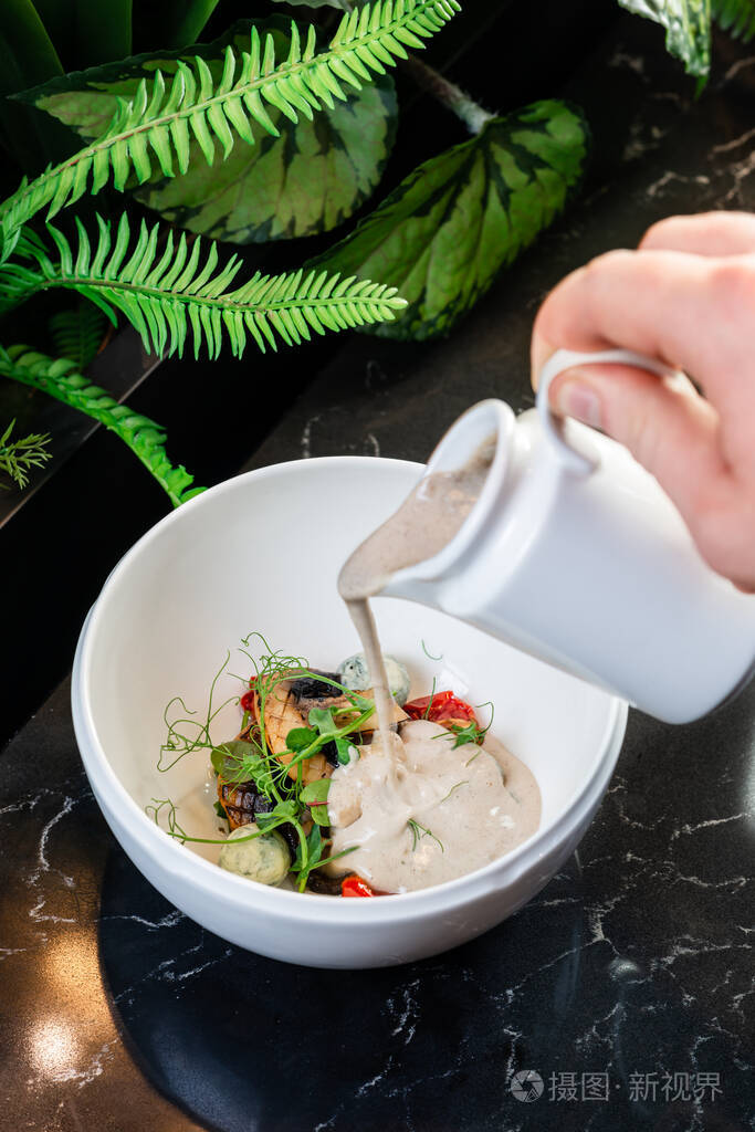 蘑菇汤原汁原味男人往盘子里倒汤