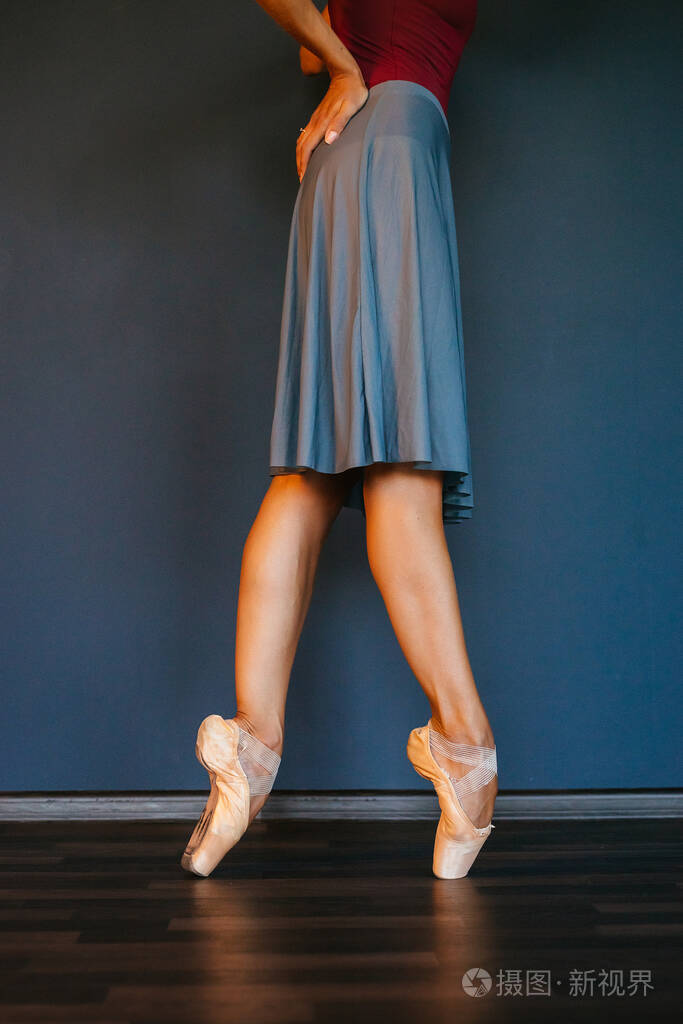 穿着尖头鞋的芭蕾舞者的腿,在黑暗的背景下,特写