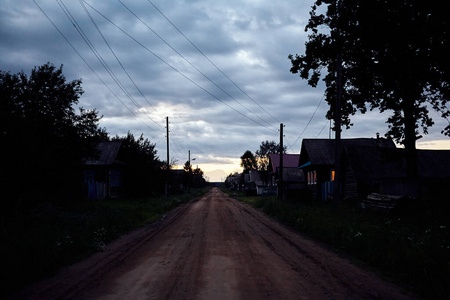  Evening rural road, houses along the street.