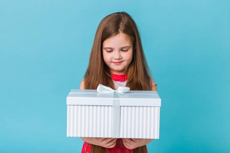 节日，礼物，圣诞节，童年和生日概念微笑的小女孩与礼品盒在蓝色背景