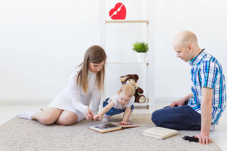 幸福的一家人,妈妈,爸爸和他们的宝宝一起在家的客厅里玩耍.