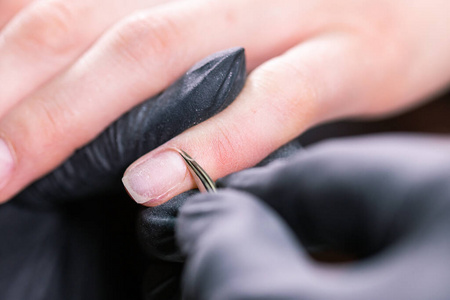 女人在美容院用电动指甲锉钻。指甲修剪过程详细。凝胶抛光特写概念。