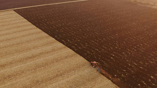拖拉机耕地的无人机视图。