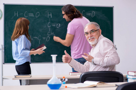 老化学家老师和两个学生在教室里