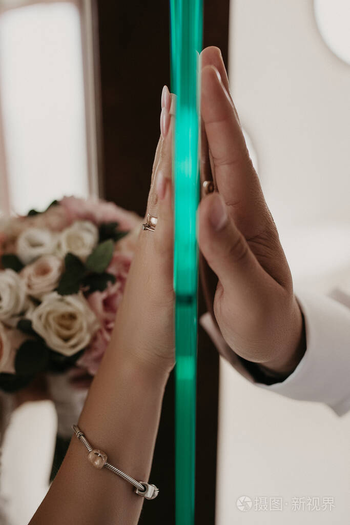 隔着隔着玻璃的人的手隔着房子的门亲密的人通过玻璃交流新娘和新郎用