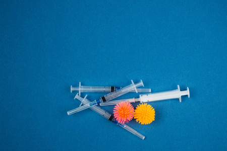 Syringes and abstract models of the 19 virus on a blue backgrou