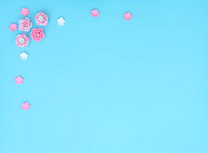 蓝色背景上由泡沫伊朗制成的粉红色和白色花朵。母亲节，情人节，婚礼，生日概念。贺卡或请柬。有复印空间的平铺。