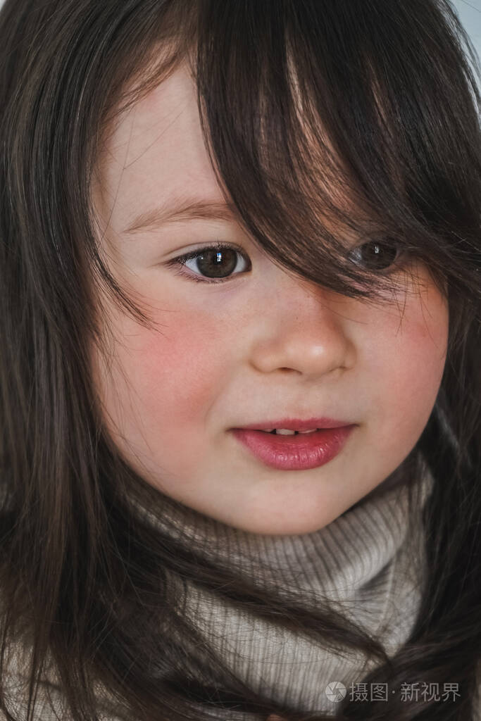 特写迷人的金发小女孩在白色背景下羞涩地向你微笑