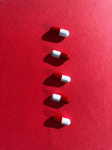 红色纹理背景上的红色和白色药丸。