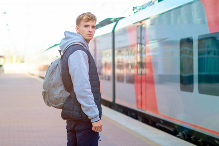 一个年轻帅哥的画像，在火车站月台上火车。