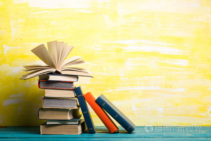 复古精装书日记木制折叠桌上扇形的书页和抽象的背景书籍堆放回到学校