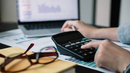 商务女性计算器和笔记本电脑，用于计算财务税务会计统计和分析研究概念