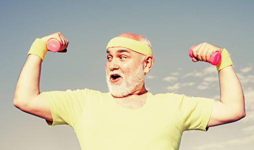 喜欢运动.健康快乐微笑老人肖像.蓝天背景上的祖父运动员肖像.