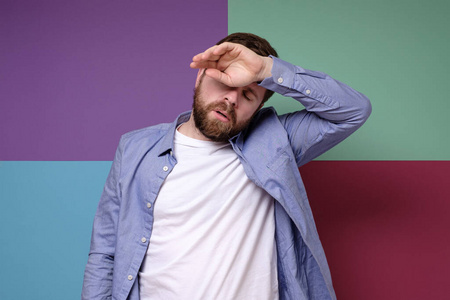 男人累了或者头疼得厉害,他把手放在额头上闭上眼睛.照片