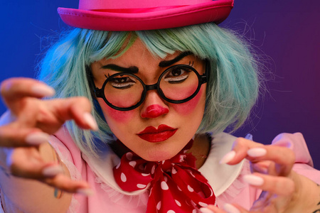 Closeup portrait of a clown girl with blue hair in a pink hat, 