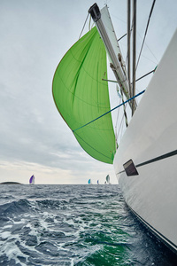 克罗地亚，亚得里亚海，2019年9月19日帆船比赛，队伍坐在船板的边缘，色彩鲜艳，从其他船只通过绳索和帆观看比赛的参与者