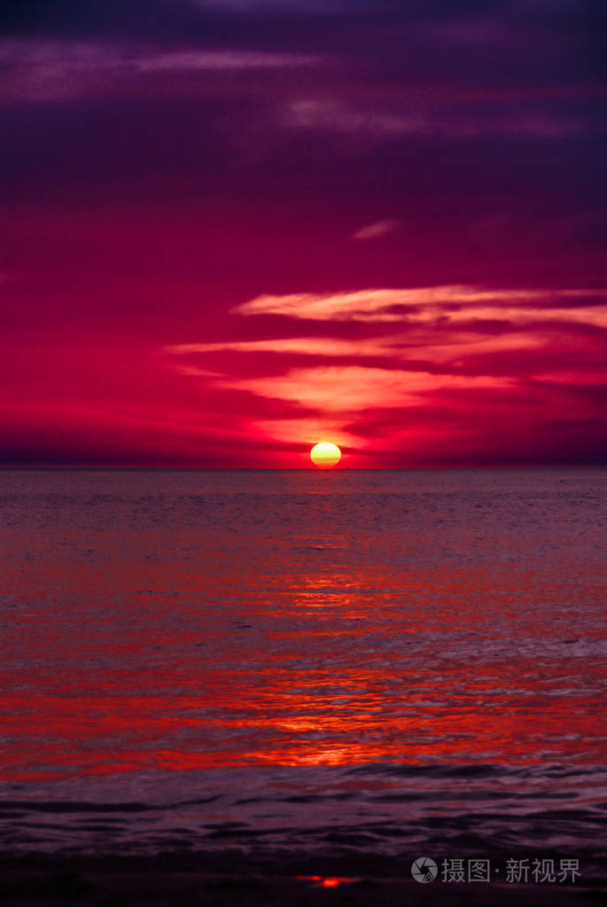 血红色和深紫色的夕阳落在阿达曼海的地平线上