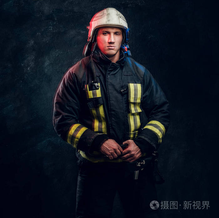 消防员身着制服戴着安全帽神情自信地侧视着