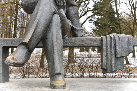 雕塑腿坐在公园的长凳上图片