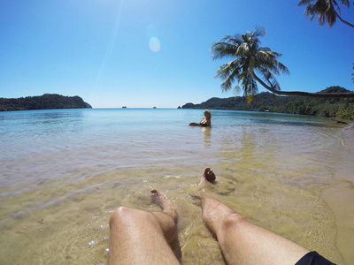 在水附近棕榈一对年轻夫妇在棕榈滩附近的海边晒太阳照片