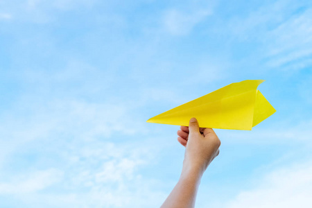飞机蓝天白云蓝天白云抽象背景上,女人手拿纸飞机.照片