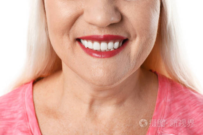 白色背景上有着完美牙齿的微笑女人特写