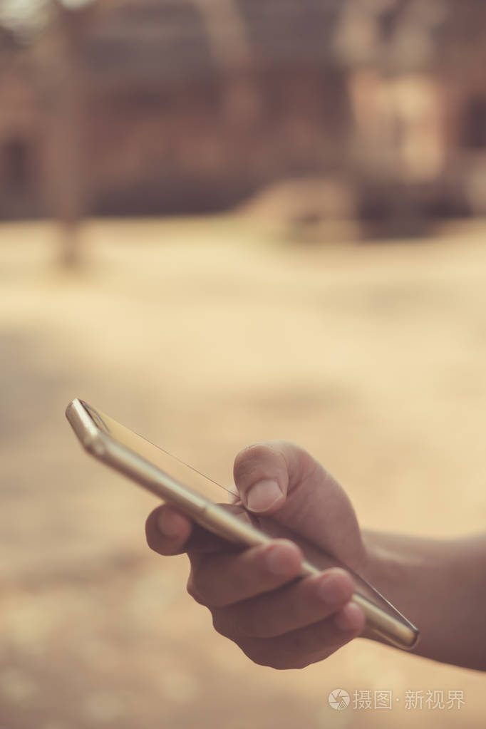 女士手拿智能手机和笔记本电脑与咖啡店的阳光阴影物体美丽的背景