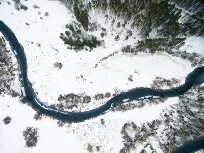 俯视河河流上的冬季景观,雪地中有森林,鸟瞰美景.