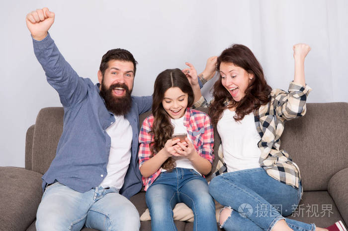 一家人一起过周末小女孩和父母一起使用智能手机友好的家庭在一起玩得