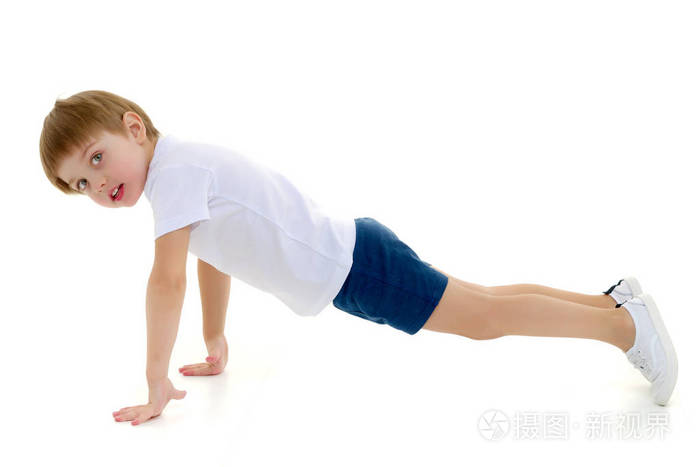 一个穿着干净白t恤的小男孩正在健身