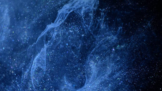 宇宙蓝色尘埃,黑色背景上有星星.粒子运动抽象.照片