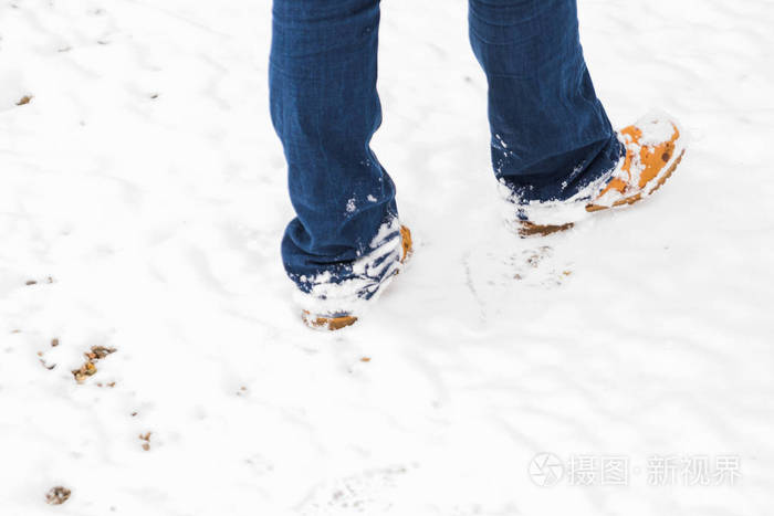 穿靴子在雪地里行走的人