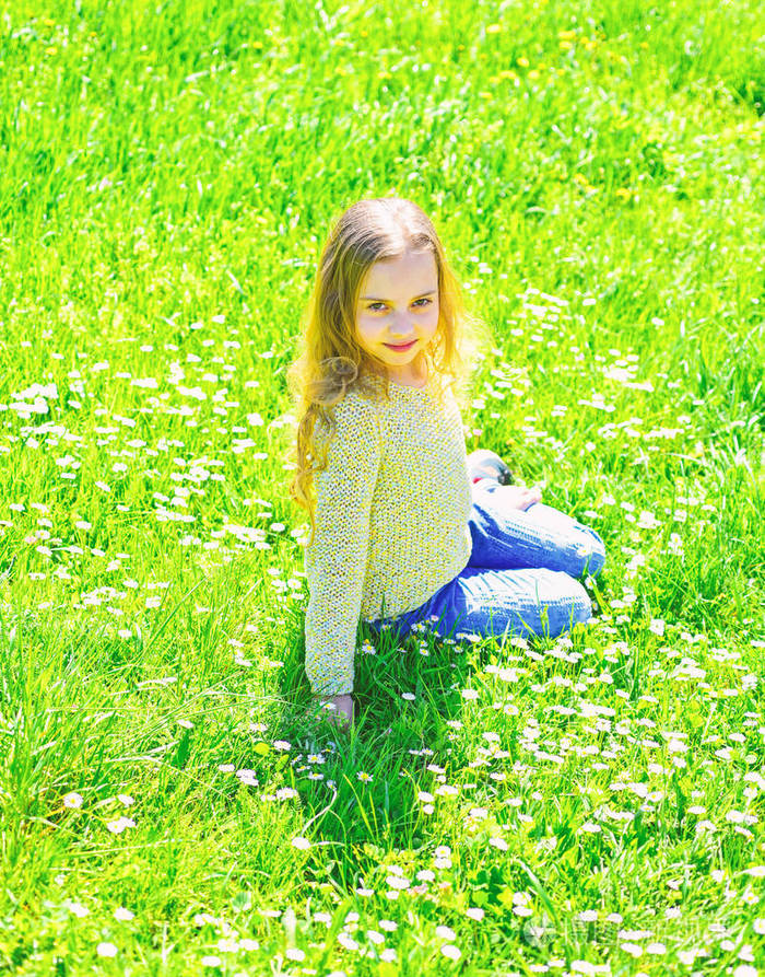 女孩坐在草地上,绿色的背景.