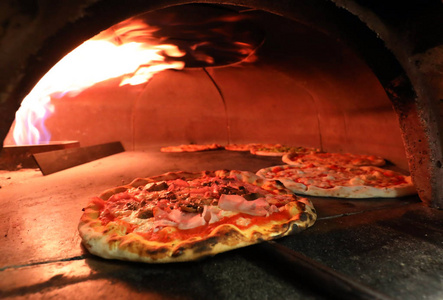 在意大利披萨店的烤箱里烧火图片