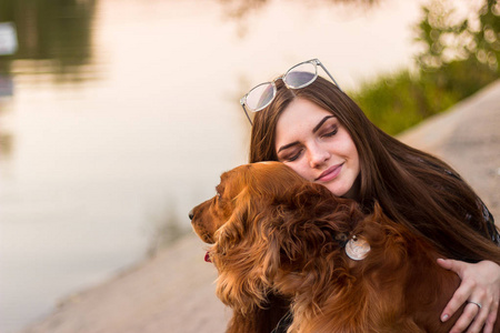 可爱的黑发女人抱着狗拥抱着.爱护动物,宠物概念照片