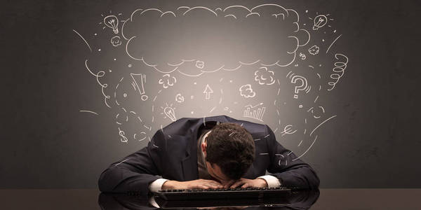 一个商人在工作场所睡着了,脑子里充满了想法,睡眠和疲惫的概念照片
