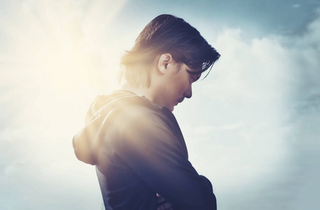 年轻人站在巨大的阳光照射下照片