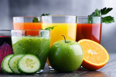 带新鲜有机蔬菜和果汁的玻璃杯在木制背景的玻璃杯里喝柠檬水用透明