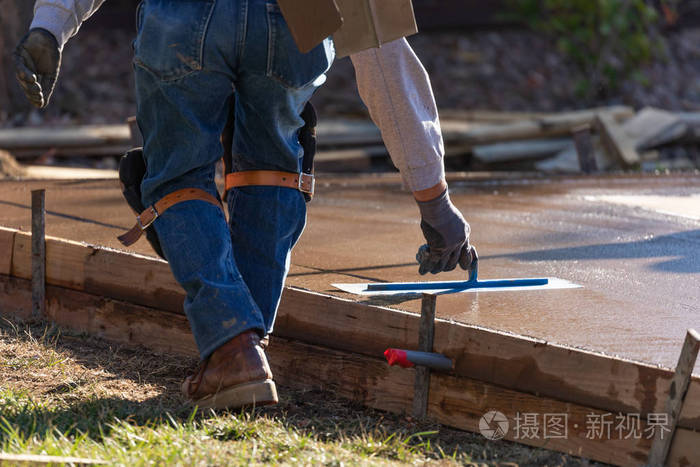 建筑工人用抹子工具抹平湿水泥