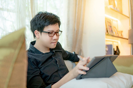 亚洲商人在客厅使用平板电脑图片