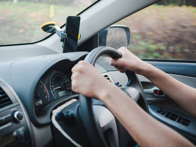 一个人拿着方向盘,在路上开车照片