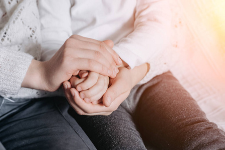 特写镜头:家人手牵着手,慈祥的母亲扶着孩子,给予心理支持,帮助或保护