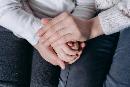 保护或给予的手特写镜头:家人手牵着手,慈祥的母亲扶着孩子,给予心理