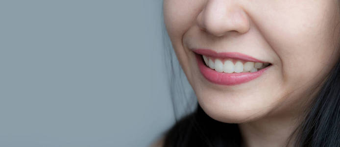 亚裔中泰女性化妆脸特写镜头.红唇唇膏女人健康牙齿洁白完美完美牙齿.