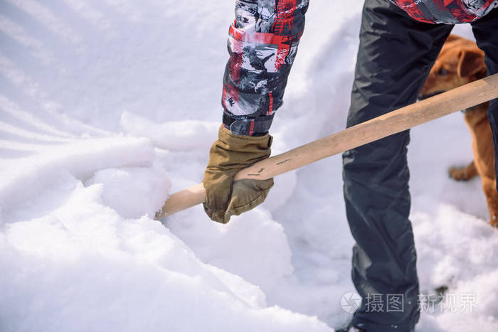 用铲子把雪擦干净那个人铲雪铲手里拿着雪铲冬天打扫这个地方